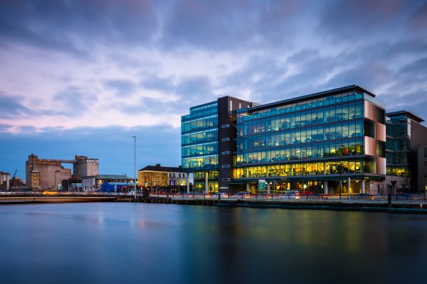 View of a corporate office across the pond against the blue sky
